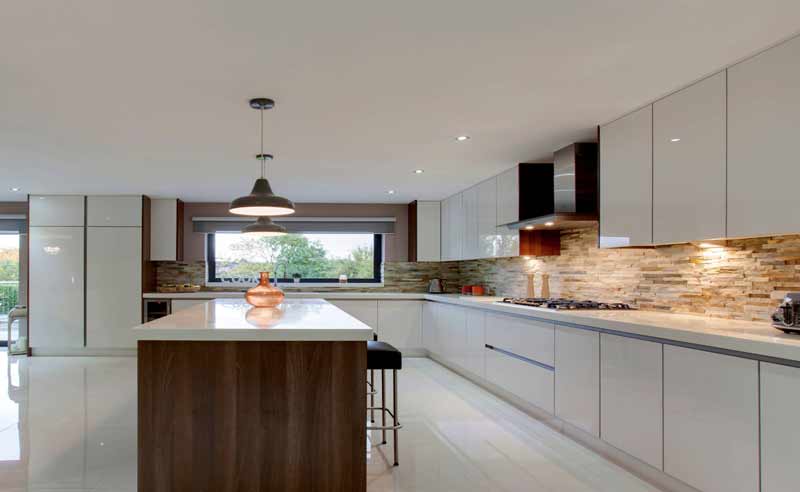 white modular kitchen in acrylics and blum fittings and island